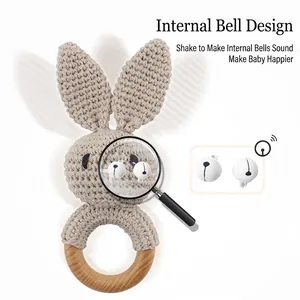 Handmade crocheted bunny baby rattle with a natural wooden ring and internal bell