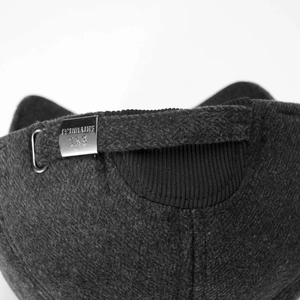 Macro detail of charcoal grey winter hat with wool texture and adjustable metal buckle