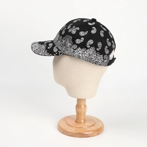 Side view of black paisley baseball cap with white pattern on professional head mold