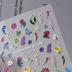 Macro shot of 3D embossed floral nail stickers featuring lily and tulip textures