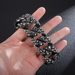 Détail d'un bracelet gourmette en acier inoxydable avec des motifs de crânes en relief