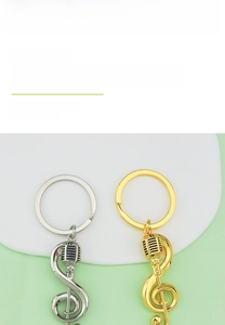 Detail of silver and gold music note keychains featuring a microphone and treble clef charm