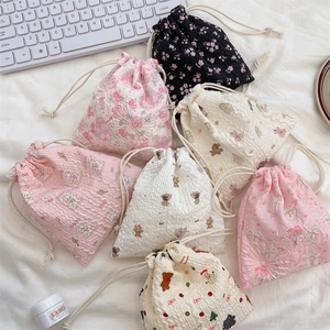 Detail of drawstring pouches with seersucker texture and assorted floral and bear patterns