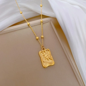 Detailed close-up of gold titanium steel pendant with Vincent and sunflower engraving