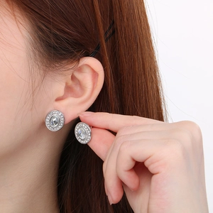 Gros plan de boucles d'oreilles ovales argentées avec grand cristal et pavé de diamants