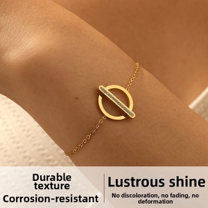 Detail shot of a minimalist gold bracelet featuring a paved zircon geometric pendant on the wrist