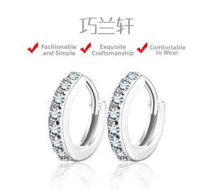 Detail of silver huggie earrings featuring a single row of sparkling pave-set zircons