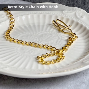 Detailed macro view of a vintage gold metal chain with a U-shaped functional hook link