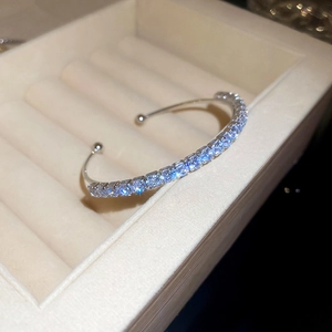 Detailed close-up of a silver open cuff bracelet with sparkling pavé zircons in a gift box