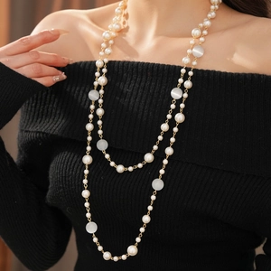 Detailed view of long multilayer necklace with white pearls and tiger eye glass beads