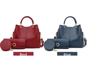 Detail view of the crocodile embossed tote bag, wallet and round pouch set in red and blue