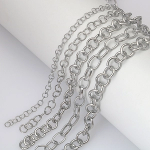 Five assorted silver stainless steel link chains for DIY jewelry making on white display