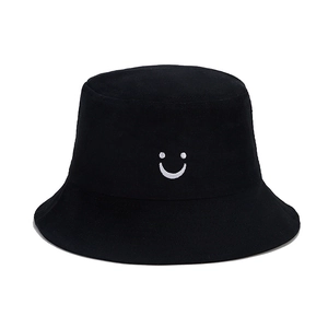 Detail of white embroidered smile face on kids black cotton sun hat for outdoor wear