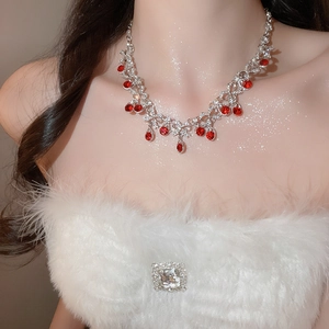 Detail of luxury teardrop silver necklace with red rubies and white crystals on a model