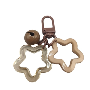 Brown acrylic star keychain with matching bell pendant on a clean white background