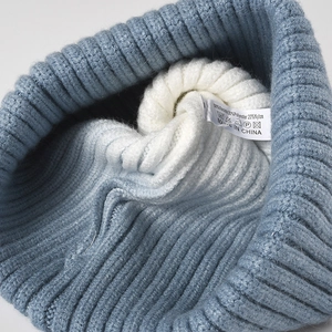 Thick blue ribbed knit beanie with white lining and detailed material washing label