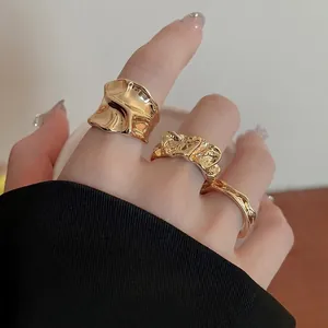 Three-piece set of irregular liquid metal gold rings with lava texture on hand