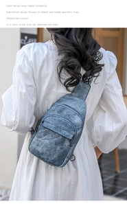 Blue textured chest bag with patterned strap and zippered pocket shown on a model outdoors