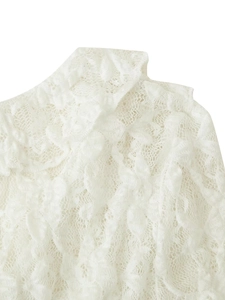 Detail shot of intricate white lace floral pattern and texture on the shoulder of the top