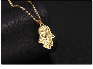 Detailed view of gold-plated Hamsa pendant necklace with heart detail and pavé setting