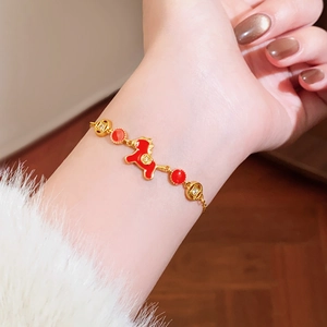 Gold plated bracelet with red enamel horse charm and sparkling zircon stones on wrist