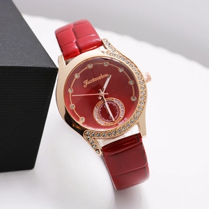 Close-up of rose gold diamond-encrusted watch with red leather strap and textured dial
