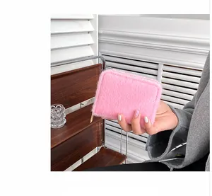 Nahaufnahme der rosa Kunstfell-Geldbörse mit goldenem Reißverschluss, von Model gehalten