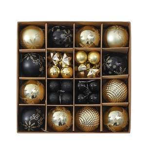 Macro view of gold and black Christmas tree ornaments in 16-piece assorted gift box