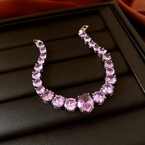 Detailed close-up of a purple tennis bracelet with an oval center stone on black leather