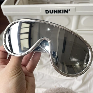 Detailed view of futuristic oversized sunglasses with a shiny silver metal frame