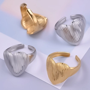 Détail de bagues ajustables en forme de cœur avec texture verticale dorée et argentée