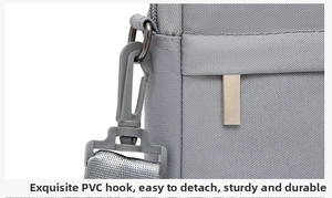Close-up of durable PVC hook and metal D-ring attachment on gray canvas laptop bag