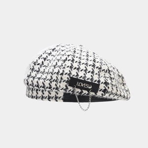 Detail of houndstooth beret with metal LOVES letters and fashion chain decoration