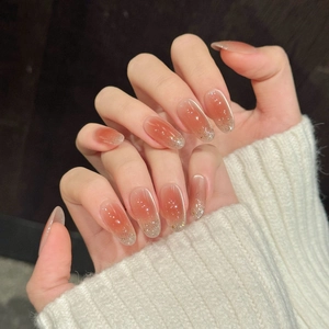 Faux ongles press-on dégradés roses avec paillettes dorées de forme ovale élégante