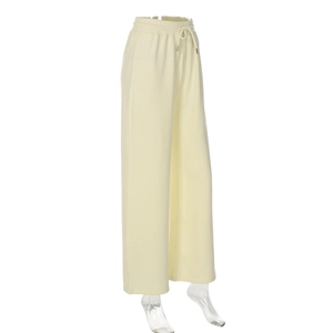 Détail du pantalon jaune à taille haute et cordon de serrage sur un mannequin clair