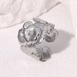 Macro shot of silver floral ring with adjustable band showing detailed layered petals