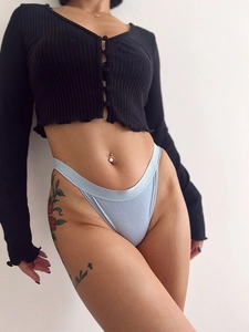Close-up of light blue high-cut cotton panties paired with a black knit cardigan