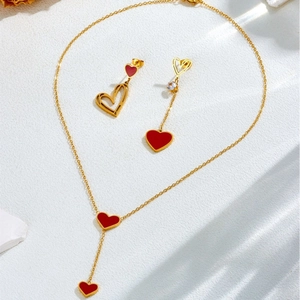 Elegant gold-tone necklace and mismatched earrings set with red heart-shaped pendants
