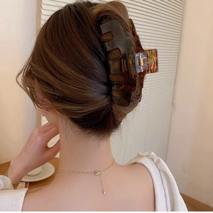 Elegant amber tortoiseshell acetate hair claw clip shown on a woman from a back view