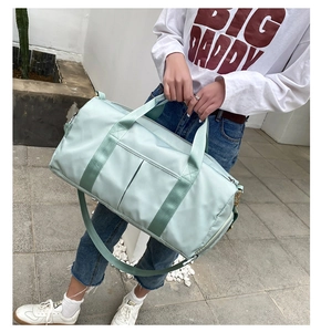 Large mint green travel bag with shoulder strap shown in a real-world outdoor lifestyle setting