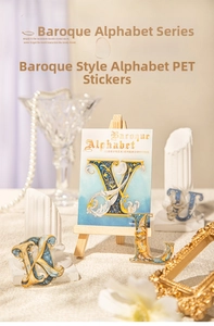 Close-up of Baroque style PET alphabet stickers with vintage gold patterns and blue tones