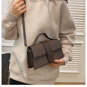 Detailed close-up of dark brown woven texture crossbody bag on a female model