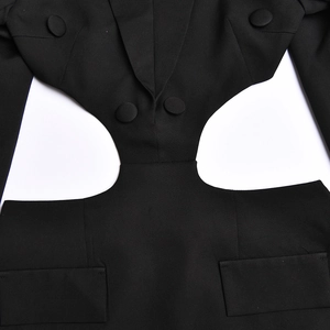 Detail shot of black cut-out dress featuring waist hollow design and button accents
