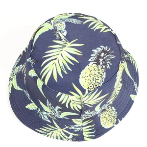 Detailed top view of navy bucket hat featuring tropical pineapple and palm leaf prints
