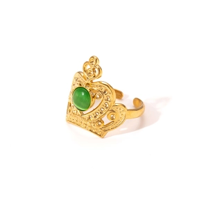 Detail of crown-shaped gold ring featuring a green gemstone on a clean white background