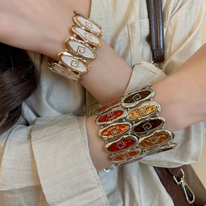 Detailed shot of retro gold and silver elastic bracelets with colorful enamel inlay