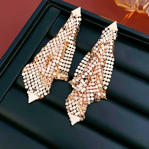 Macro shot of rose gold mesh fringe earrings with geometric sequins on jewelry tray