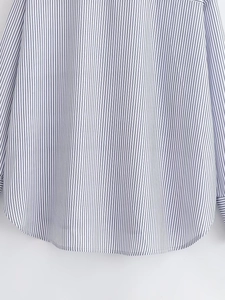 Detailed close-up of blue and white vertical striped shirt featuring a curved hemline