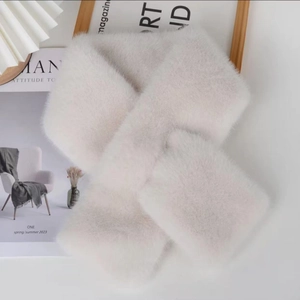 Close-up of soft white faux mink fur scarf texture with cozy home decor background