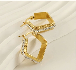 Macro shot of 18K gold-plated square earrings with zircon studs and Greek fret pattern